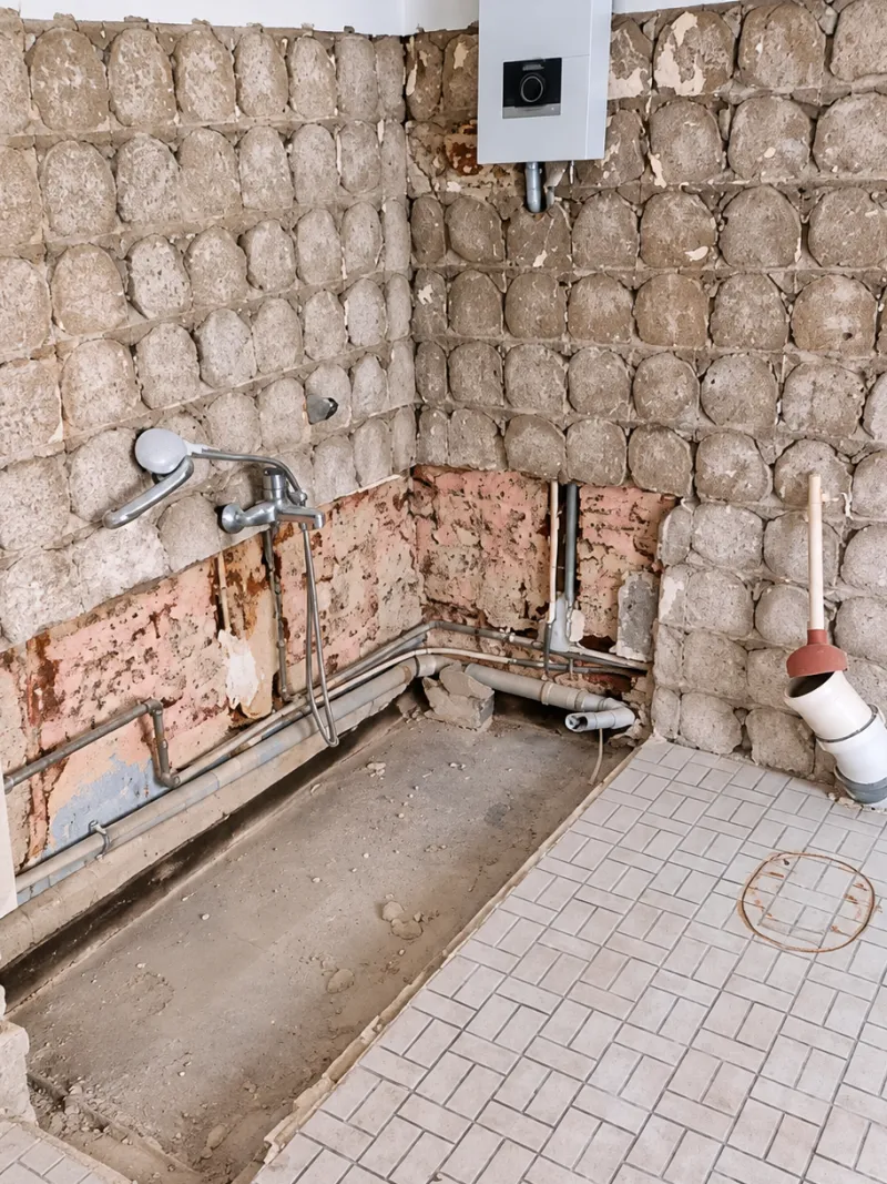The same bathroom after the tiles, bathtub and toilet were removed