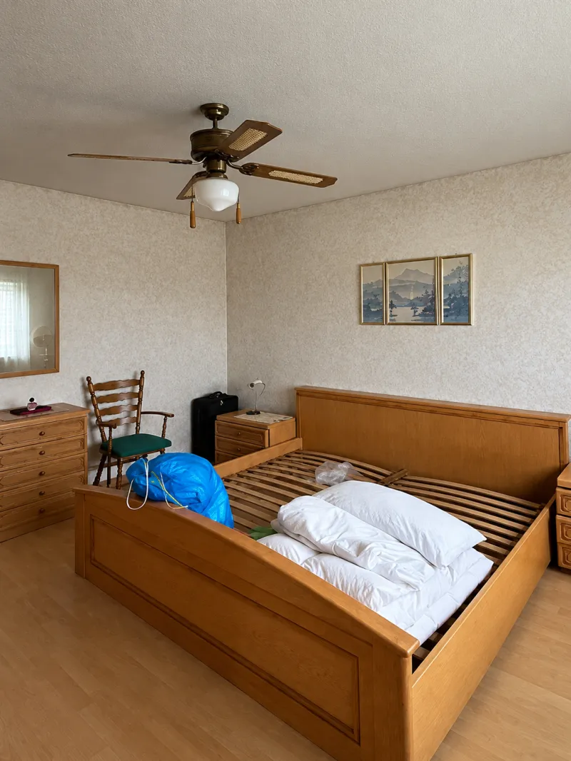 Bedroom with a wooden bed frame, chest of drawers and chair