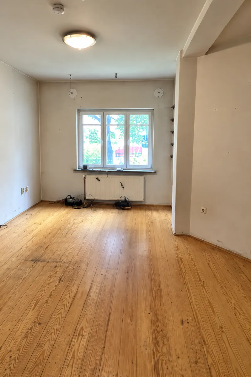 The same room cleared, with an empty wooden floor